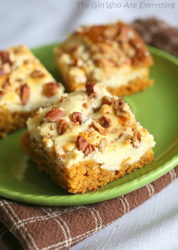 These Pumpkin Cream Cheese Bars are moist pumpkin bars with swirls of cream cheese throughout. This will be on your fall treat list every year. the-girl-who-ate-everything.com